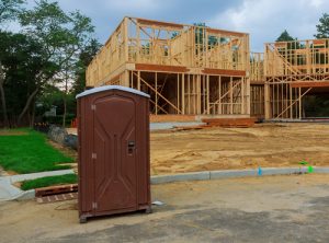 regular porta potty near a new home construction site
