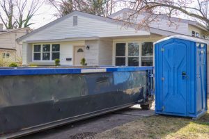 Deluxe porta potty in baltimore next to a dumpster